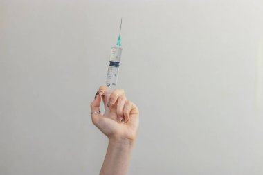 Şırınga, elinde tıbbi enjeksiyon, avuç içi ya da parmak. İğneli tıbbi plastik aşı ekipmanı. Hemşire ya da doktor. Sıvı uyuşturucu ya da uyuşturucu. Hastanede sağlık hizmeti.