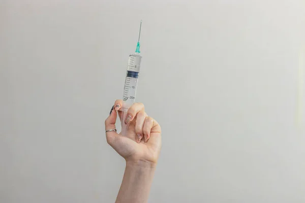 Syringe, medical injection in hand, palm or fingers. Medicine plastic vaccination equipment with needle. Nurse or doctor. Liquid drug or narcotic. Health care in hospital. — Stock Photo, Image