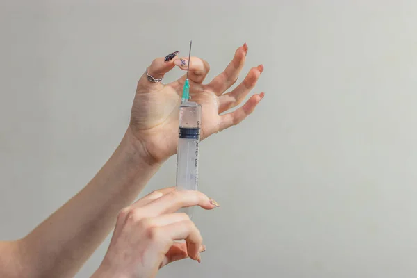 Syringe, medical injection in hand, palm or fingers. Medicine plastic vaccination equipment with needle. Nurse or doctor. Liquid drug or narcotic. Health care in hospital. — Stock Photo, Image