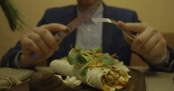 Man die smakelijk vlees eet met vork en mes. Close-up hand — Stockvideo