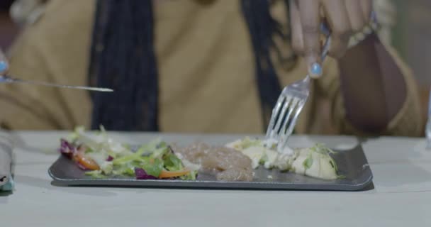 Mujer africana comiendo sabrosa ensalada en la cafetería. De cerca la mano — Vídeos de Stock