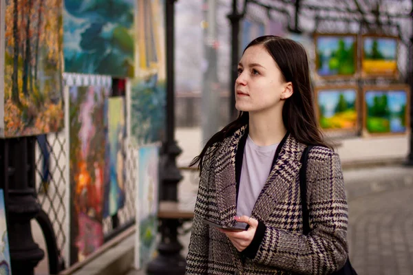 Genç kadın sanat galerisi modern resim bakarak