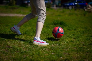 Bir futbol topuna ve bir futbolcunun ayaklarına yakın dur.