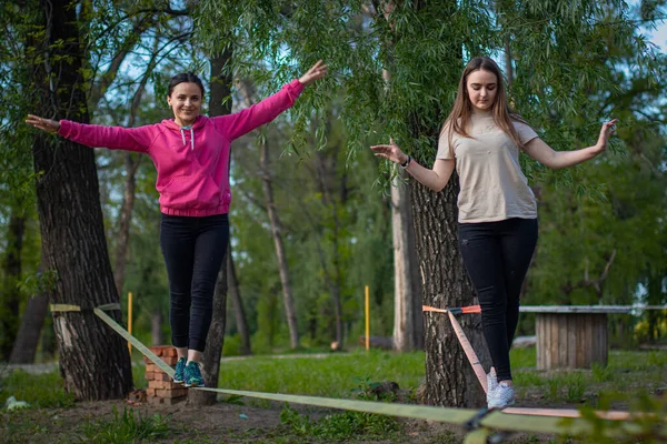 Dois Adolescente Balanceando Slackline Com Vista Para Céu Imagem De Stock