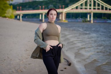 Yakın plan moda kadın portresi. Plajda poz veren güzel moda kızı. Plajda şık, esmer bir kadın.