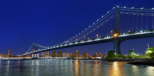 Panorama of Manhattan bridge at nigt lights view from Brooklyn park