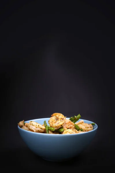 Fried shrimps and asparagus in a bowl