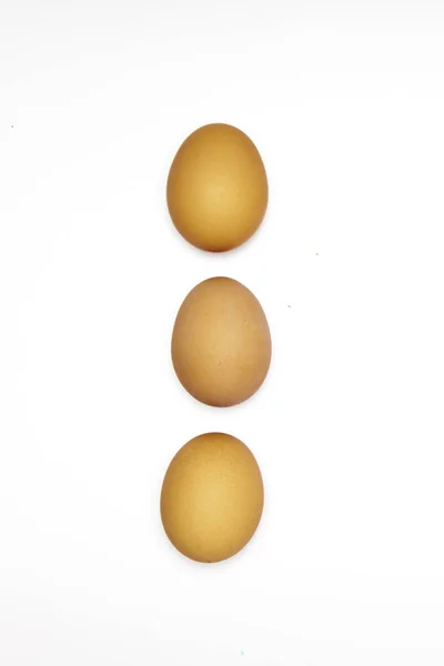 Fila hecha de tres huevos marrones . — Foto de Stock
