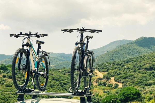 Dos bicicletas montadas en el techo de un coche . — Foto de Stock