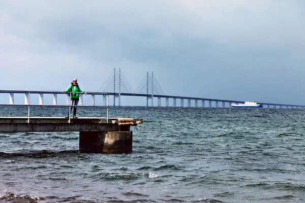 Mutlu kadın turist Öresund Köprüsü arka plan üzerinde poz.