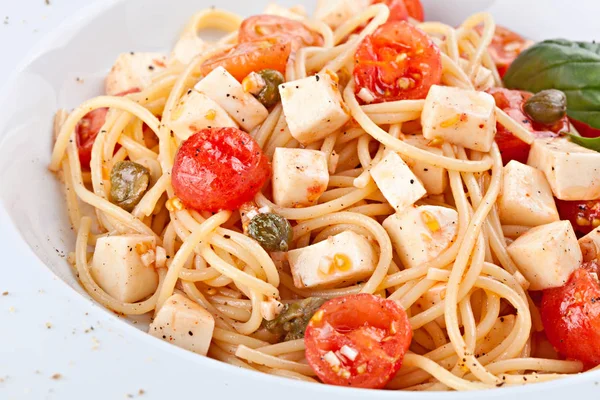 Primer plano de la pasta italiana con tomates cherry, alcaparras y quesos —  Fotos de Stock