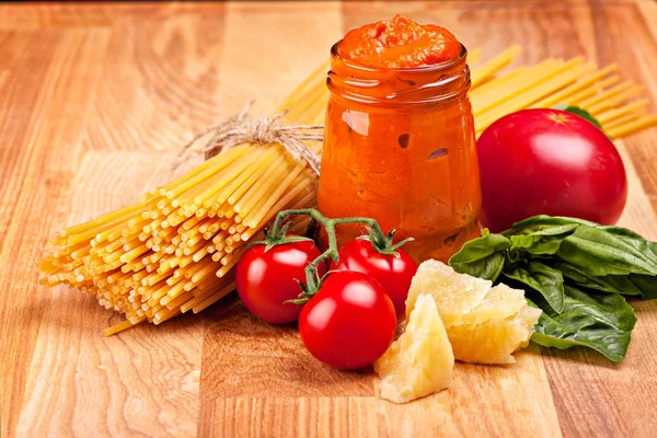 Spaghetti, grönsaker, bit ost och pesto sås på trä — Stockfoto