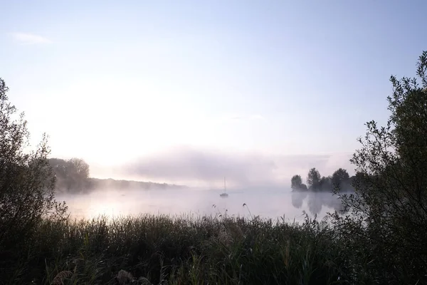Πρωινή ομίχλη πάνω από λίμνη με ιστιοφόρο - 1 Royalty Free Εικόνες Αρχείου