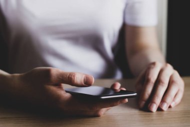 Akıllı telefon kullanan genç bir kadın.