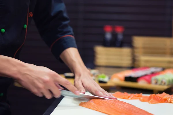 Preparación de un rollo de sushi en el restaurante, de cerca en las manos del chef — Foto de Stock