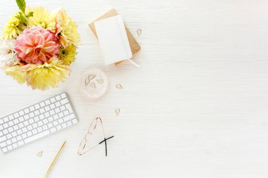 Lay kadın Ofis Masası düz. Pembe ve sarı dahlias ve gül çiçek buketi, aksesuarlar, altın günlüğü, beyaz tahta üzerine gözlük ile kadın çalışma alanı 