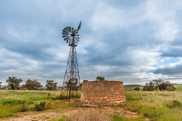 Paisaje rural australiano con antigua bomba de agua rústica molino de viento a — Foto de Stock