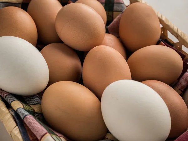 Huevos en una cesta de paja sobre una mesa . — Foto de Stock