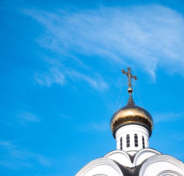 Mavi gökyüzü arka plan üzerinde bir haç ile bir kilisenin kubbesi