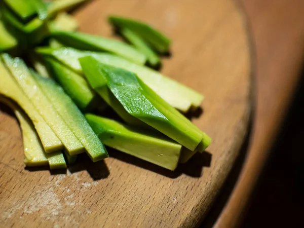 Pieces of avocado chopped on a board, cooking — Stock Photo, Image