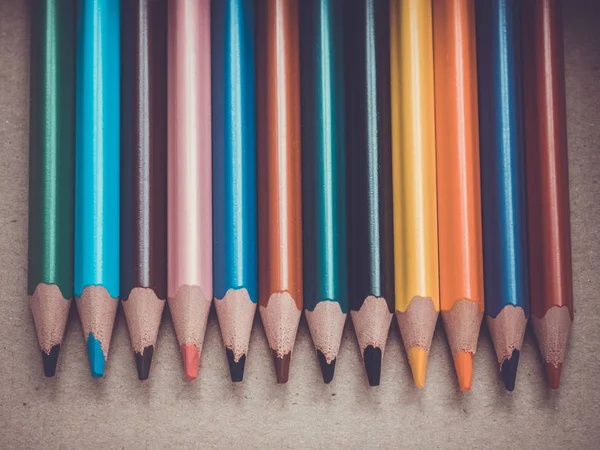 Un conjunto de varios lápices de colores. Lápices en fila sobre una superficie de madera . — Foto de Stock