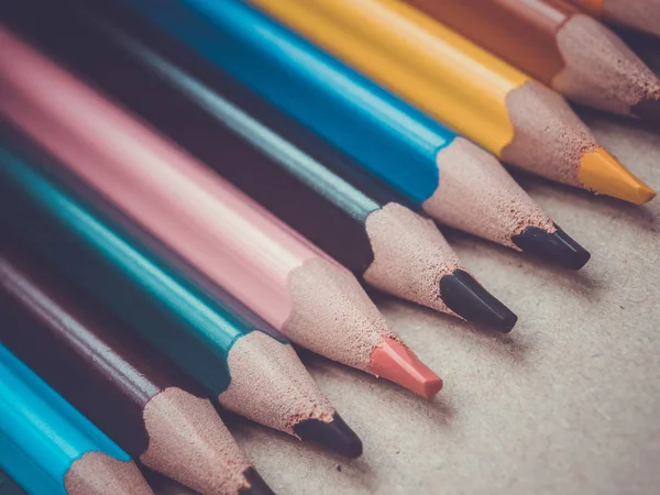 Un conjunto de varios lápices de colores. Lápices en fila sobre una superficie de madera . — Foto de Stock