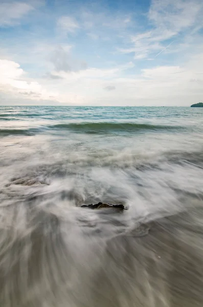 Immagine offuscata.onda bianca morbida che colpisce la spiaggia a causa della lunga esposizione — Foto Stock