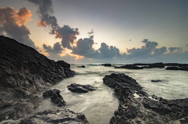 Bela natureza, ondas salpicando sobre a formação de rochas únicas sobre belo fundo do nascer do sol — Fotografia de Stock