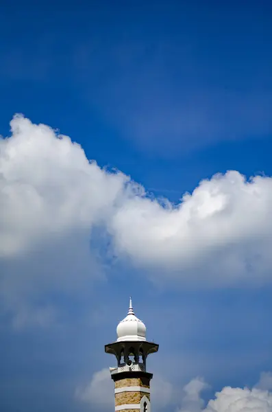 Минарет мечети Джамек расположен в Куала-Лумпуре, Малайзия, на фоне голубого неба в солнечный день — стоковое фото