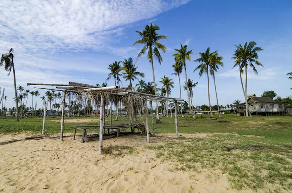 Hermoso paisaje rural con casa de madera y techo frondas en la playa de arena — Foto de Stock