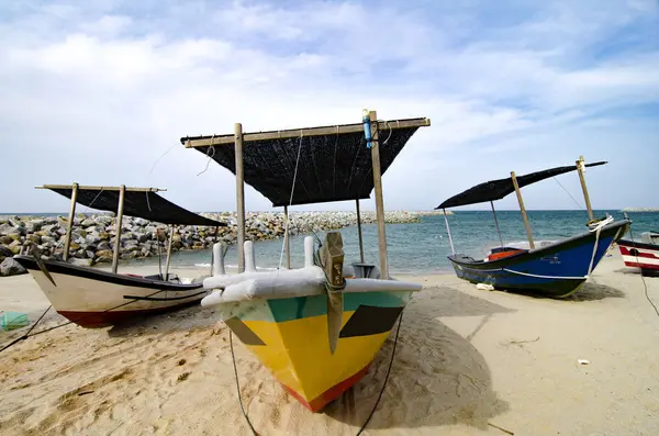 Fechado pescador barco encalhado na praia de areia e céu nublado — Fotografia de Stock