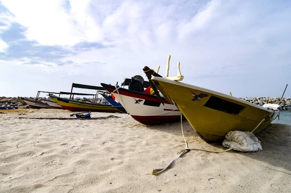 Geschlossenes Fischerboot am Sandstrand gestrandet und bewölkt — Stockfoto