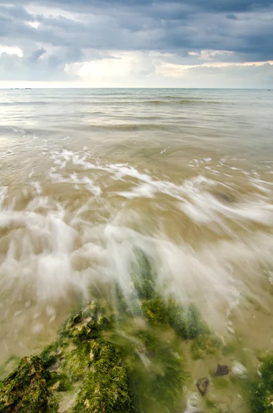 Bella onda bianca e morbida scorrono sopra la roccia e muschioso colpire la riva — Foto Stock