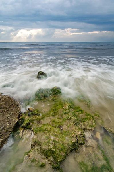 Bella onda bianca e morbida scorrono sopra la roccia e muschioso colpire la riva — Foto Stock