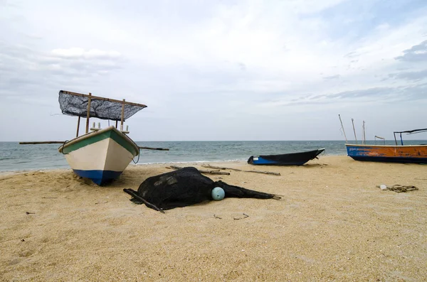 Geschlossenes Fischerboot am Sandstrand und bewölktem Himmel gestrandet — Stockfoto