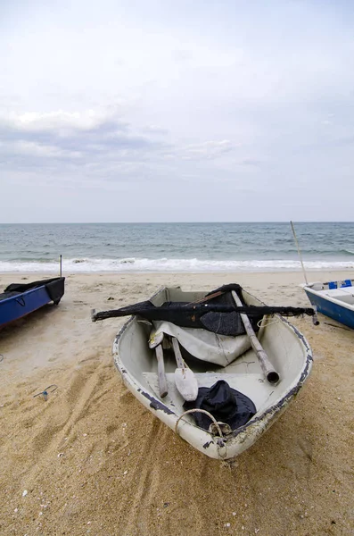 Geschlossenes Fischerboot am Sandstrand und bewölktem Himmel gestrandet — Stockfoto