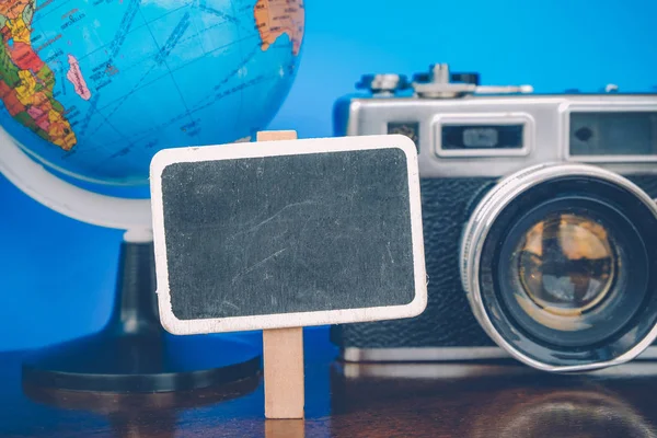 Voyage et vacances concept image, toile blanche, globe et vintage disposition de l'appareil photo sur un bureau en bois — Photo