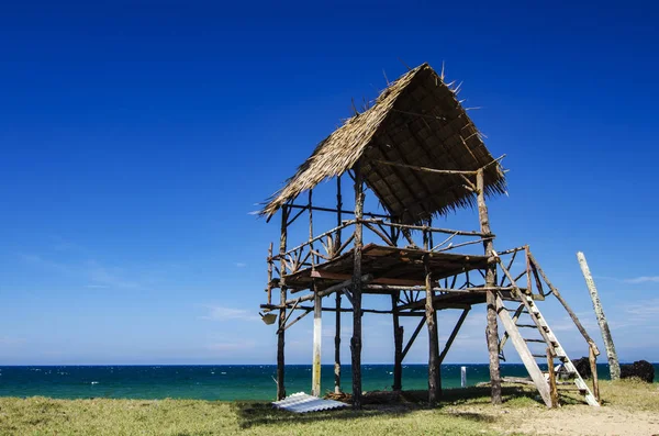 Vue sur la mer tropicale sous une cabane en bois par temps ensoleillé. plage de sable et ciel bleu — Photo