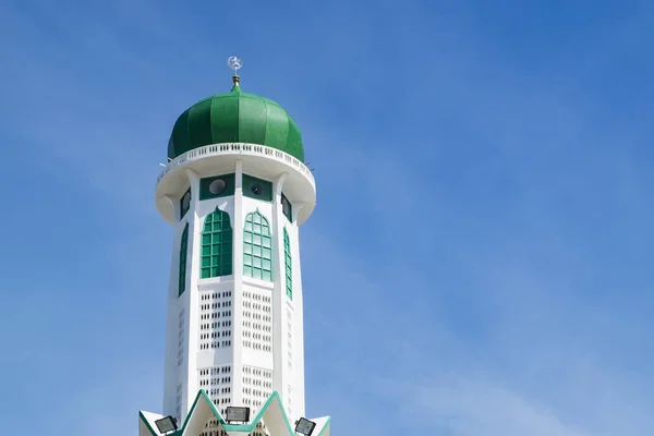 Башня мечети и зеленый купол на фоне голубого неба — стоковое фото