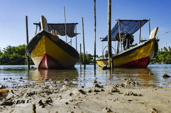 Barco pescador malaio tradicional ancorado perto da margem do rio sobre fundo céu azul — Fotografia de Stock