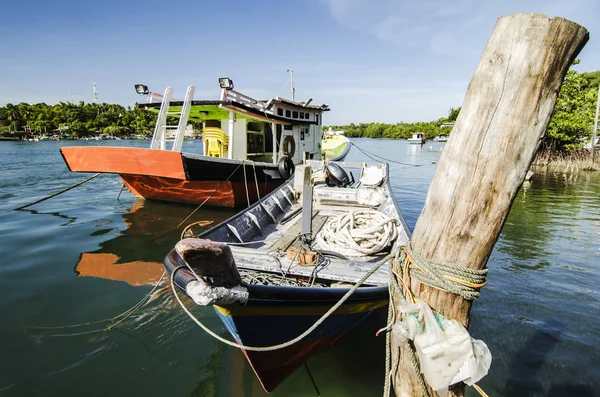 Barco tradicional pescador malayo amarrado, embarcadero de madera y fondo cielo azul — Foto de Stock