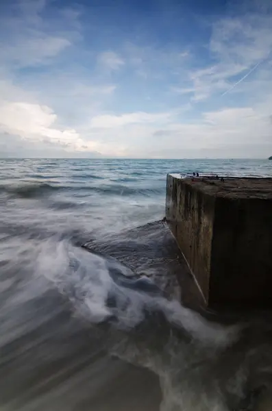Fluxo suave onda batendo na praia arenosa sobre background de céu nublado — Fotografia de Stock