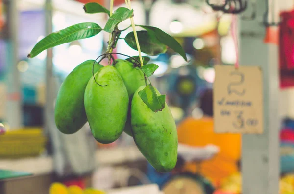 Fruits exotiques tropicaux, mangue verte suspendue dans le marché frais — Photo