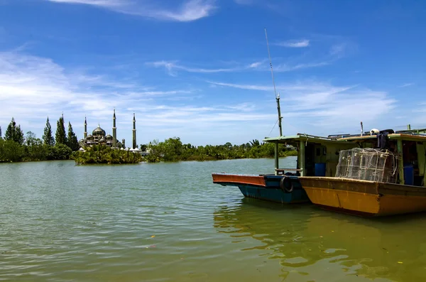 Loď kotvící poblíž břehu řeky crystal mešitu a modrá obloha pozadí slunečný den v Terengganu, Malajsie — Stock fotografie