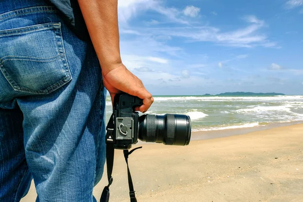 Przycięte zdjęcie, człowieka stojącego z kamery w pobliżu brzegu w słoneczny dzień — Zdjęcie stockowe