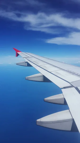 View from aircraft window, wing of aeroplane over blue sky ideal for travel concept — Stock Photo, Image