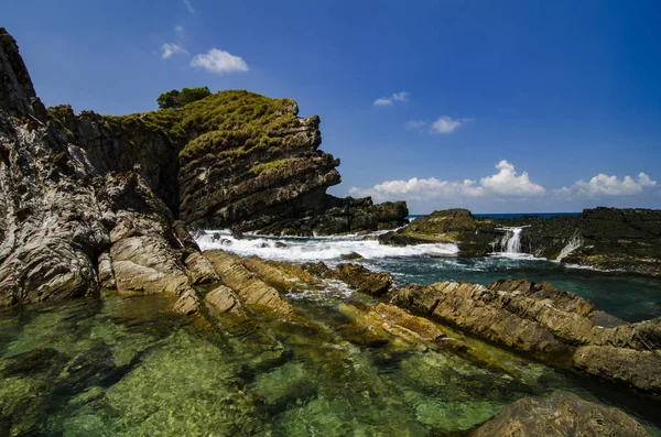 Hidden beauty nature of Kapas Island located in Malaysia, magical rock formation over blue sky background