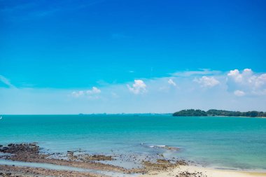 Mavi gökyüzü arka plan ve beyaz ıssız kum ile güneşli gün güzel tropikal plaj