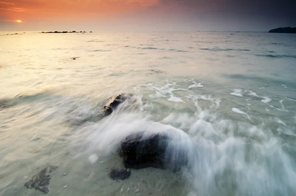 Belo e mágico momento de nascer do sol perto da costa do mar com céu nublado.onda suave atingindo a praia arenosa . — Fotografia de Stock
