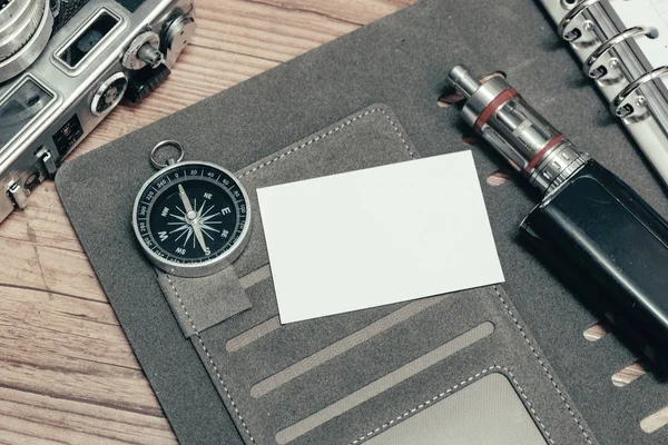 Imago van het concept reizen bedrijf, bovenaanzicht naam kaart op persoonlijke planner boek, vintage camera en de achtergrond van de houten vloer — Stockfoto